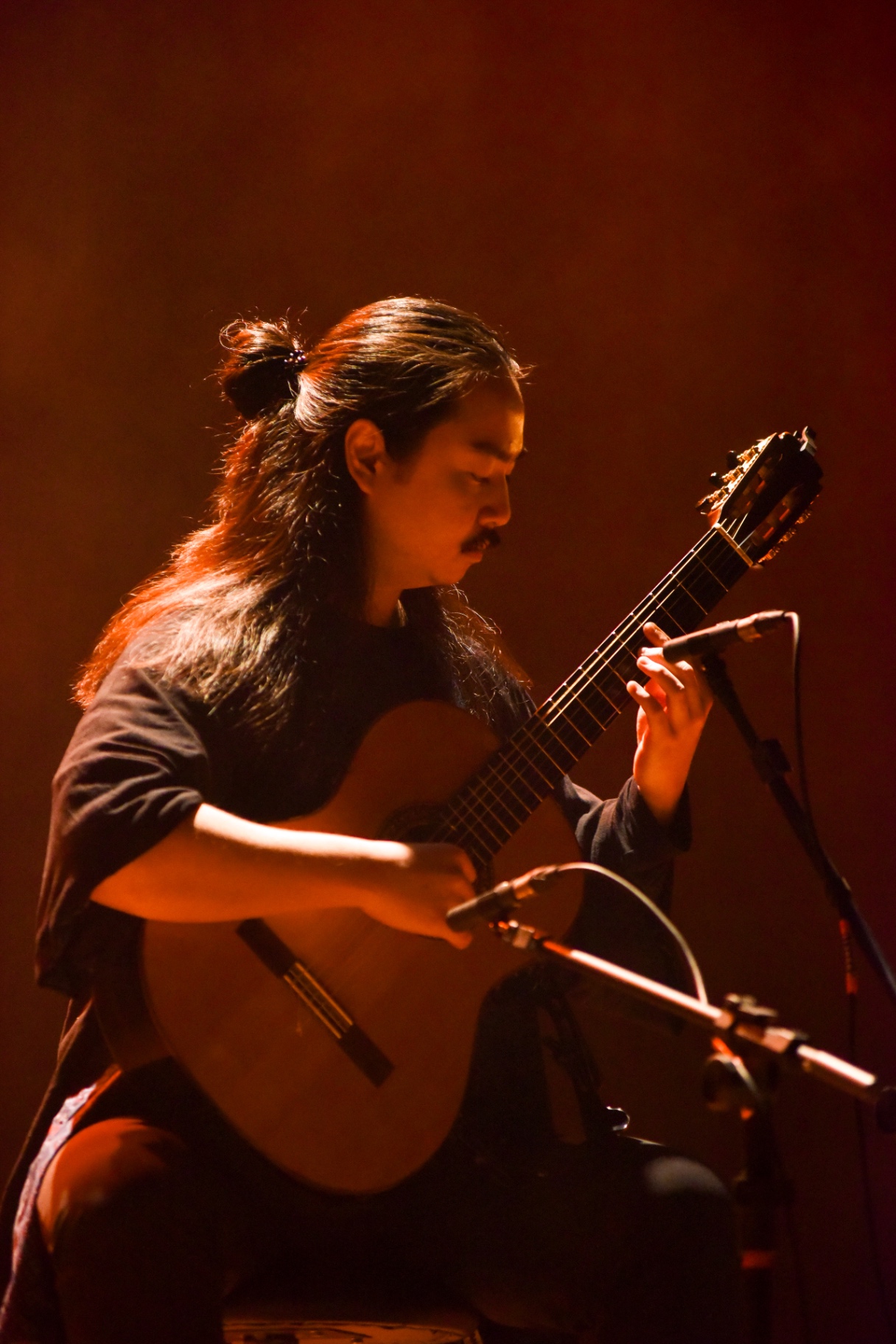 Musician playing classical guitar in warm lighting